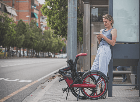 eine Dame neben einem Faltrad